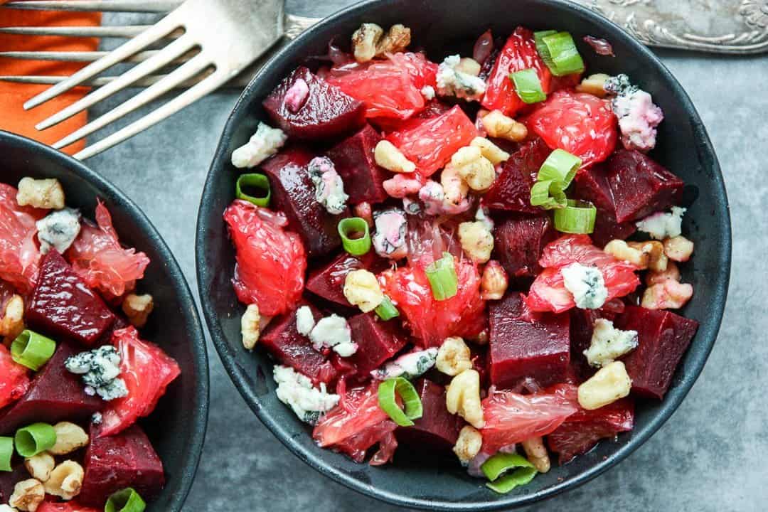 Salad with nuts and blue cheese crumbles in black bowls