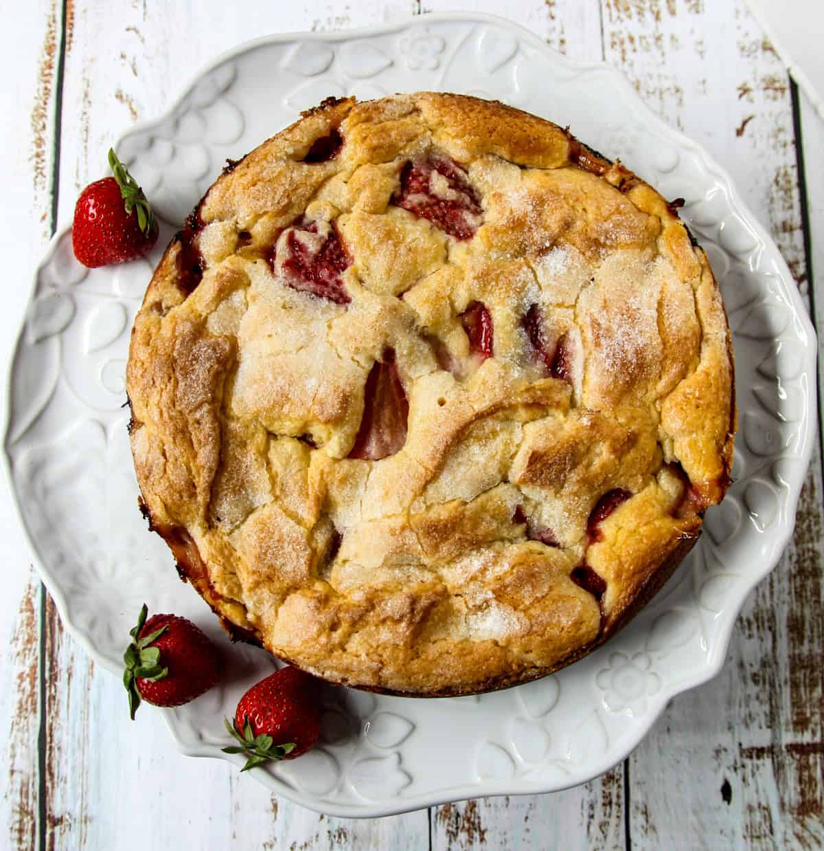 French strawberry cake on a white cake platter.
